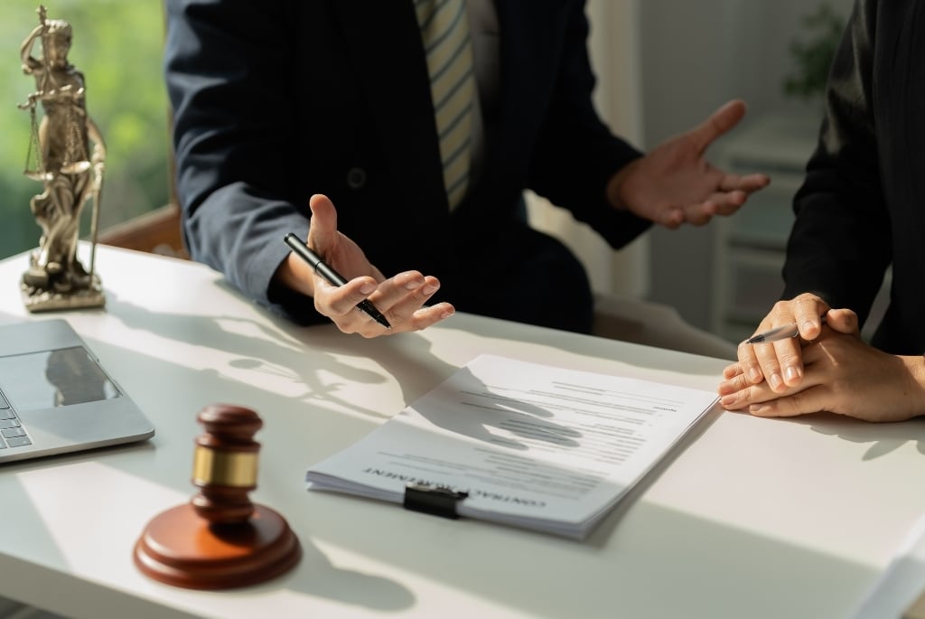 Lawyer sitting at desk explaining things to client who needs outside counsel