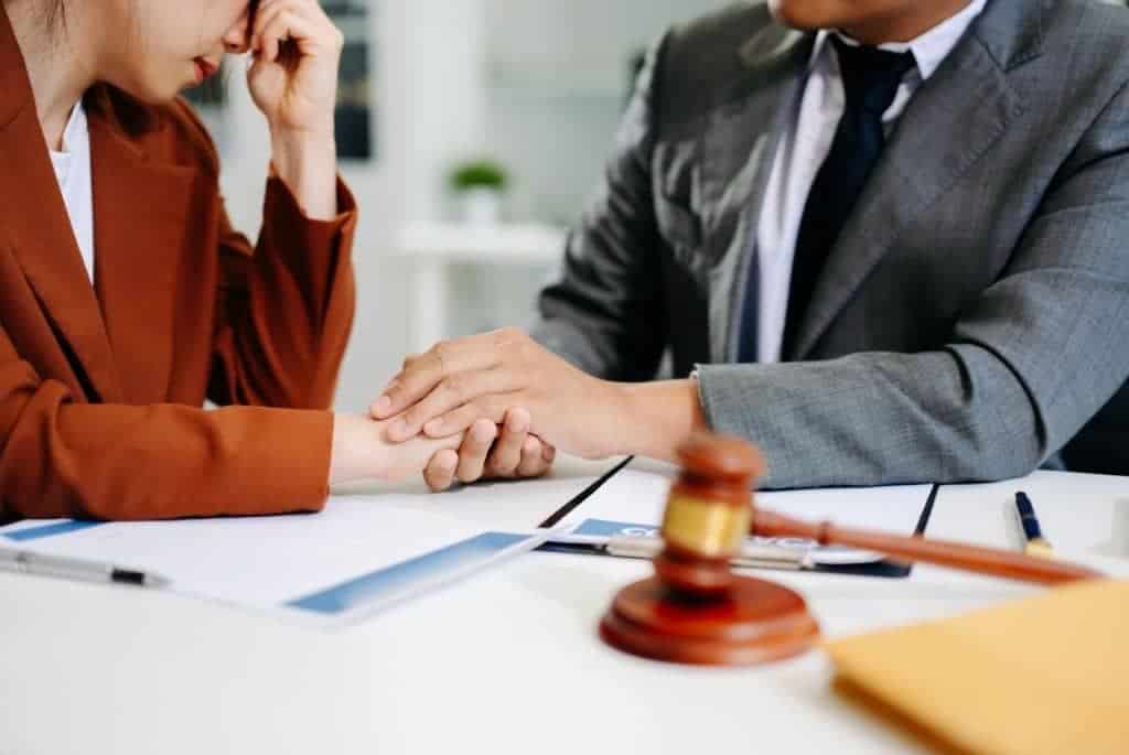 Family law attorney holding the hand of an emotional client